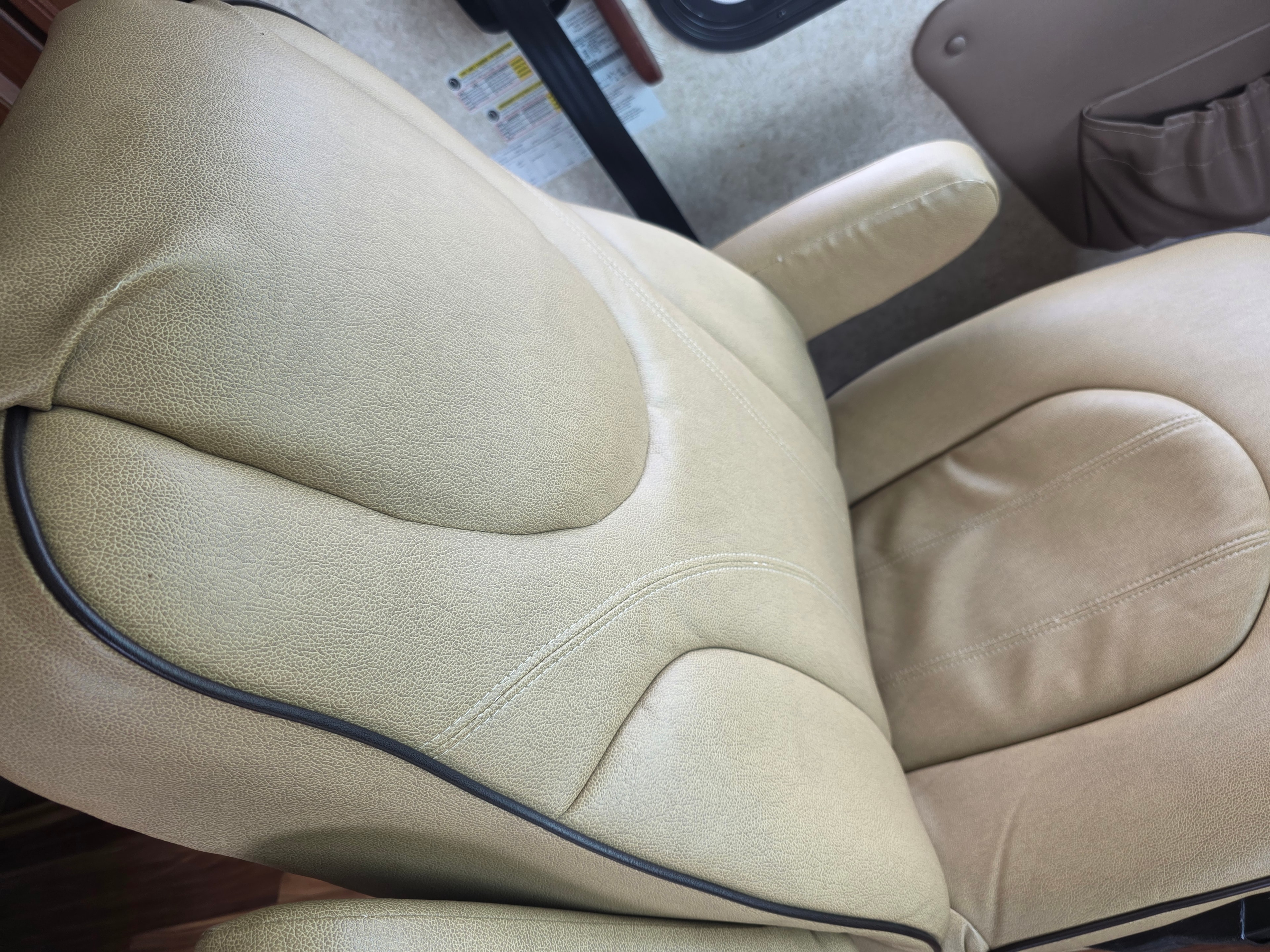 2014 Forest River Georgetown – driver captain chair close-up showing cream leather with dark piping in excellent condition