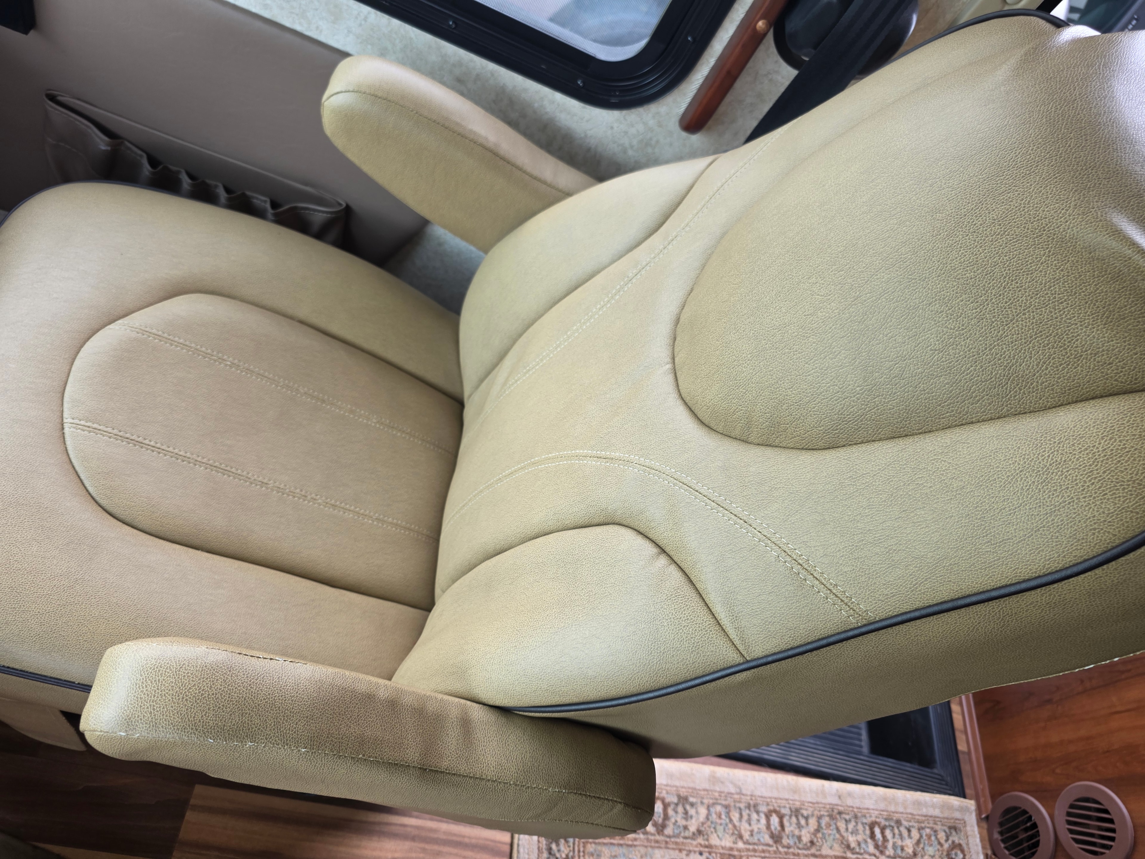 2014 Forest River Georgetown – passenger captain chair close-up showing tan leather with dark piping in excellent condition