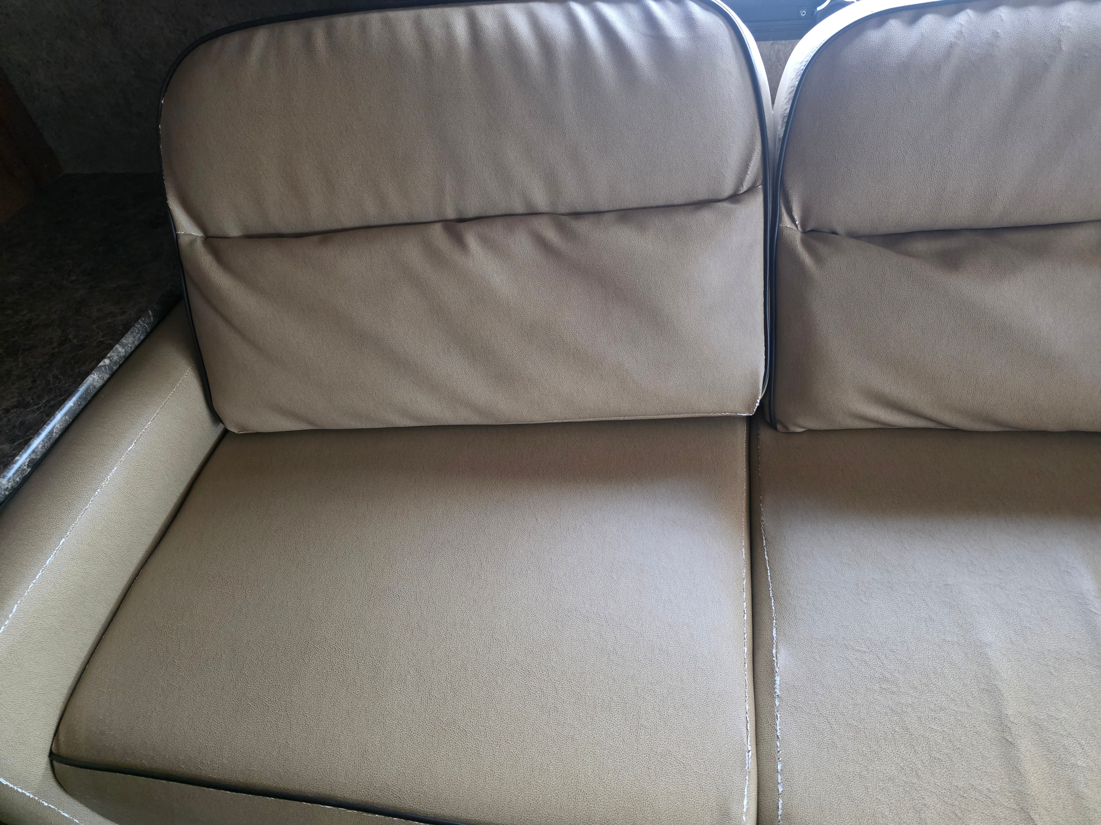2014 Forest River Georgetown – tan leather sofa close-up showing clean cushions with no peeling or wear