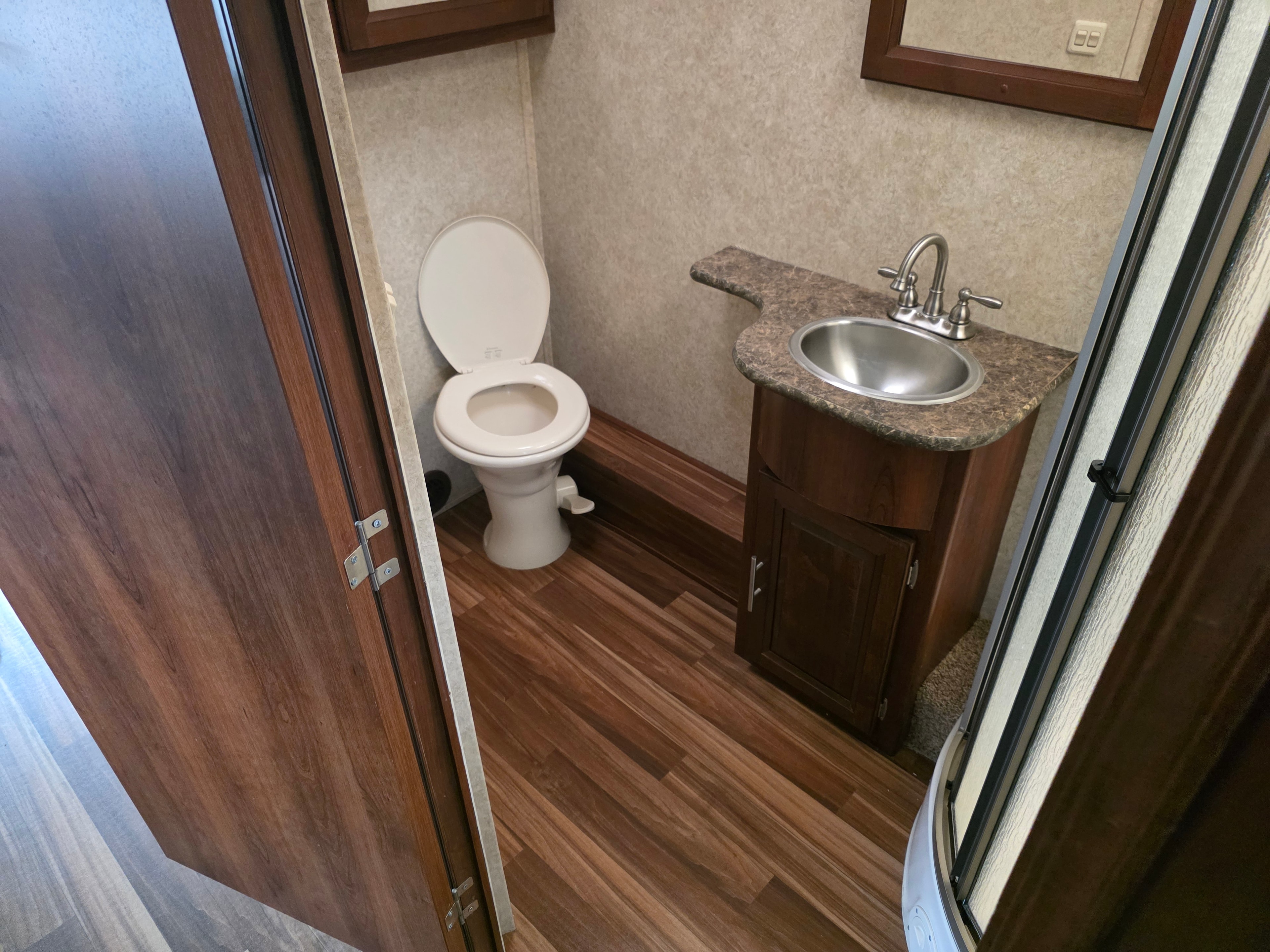 2014 Forest River Georgetown – bathroom with toilet, round stainless sink, granite vanity and wood-look flooring