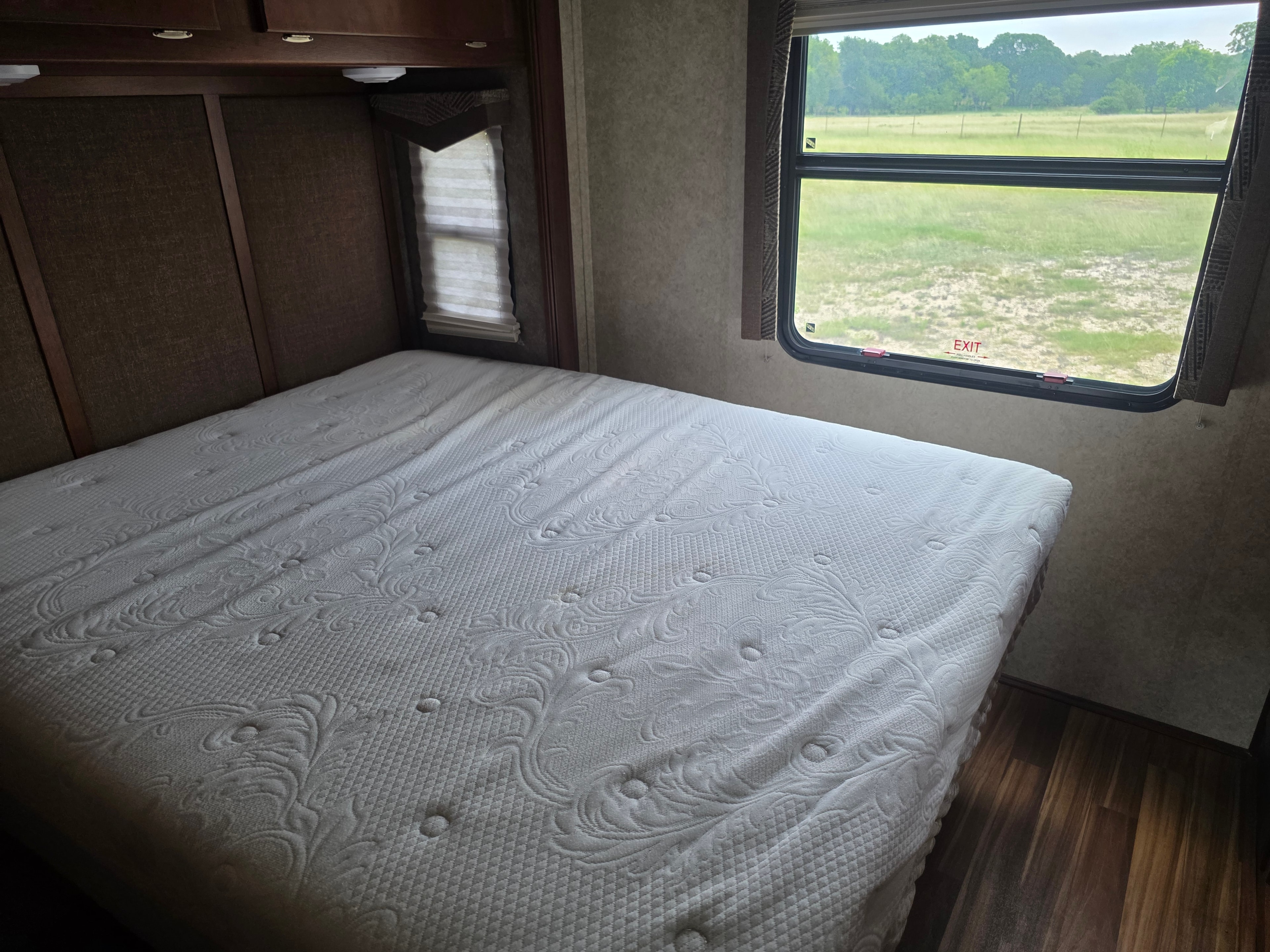 2014 Forest River Georgetown – bedroom with queen mattress on bed slide, overhead cabinets and exit window