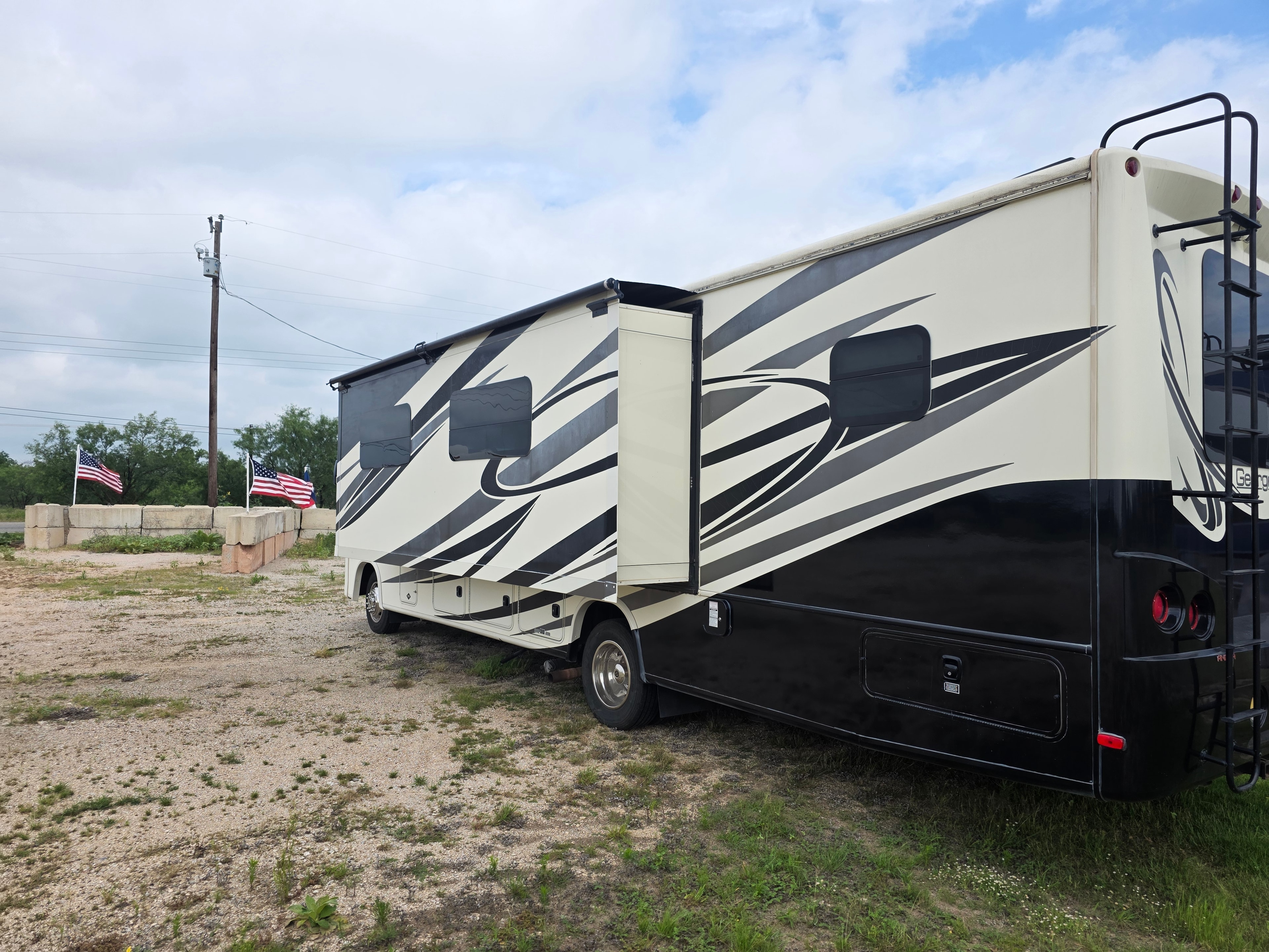 2014 Forest River Georgetown – rear three-quarter with super slide extended and American flags in background