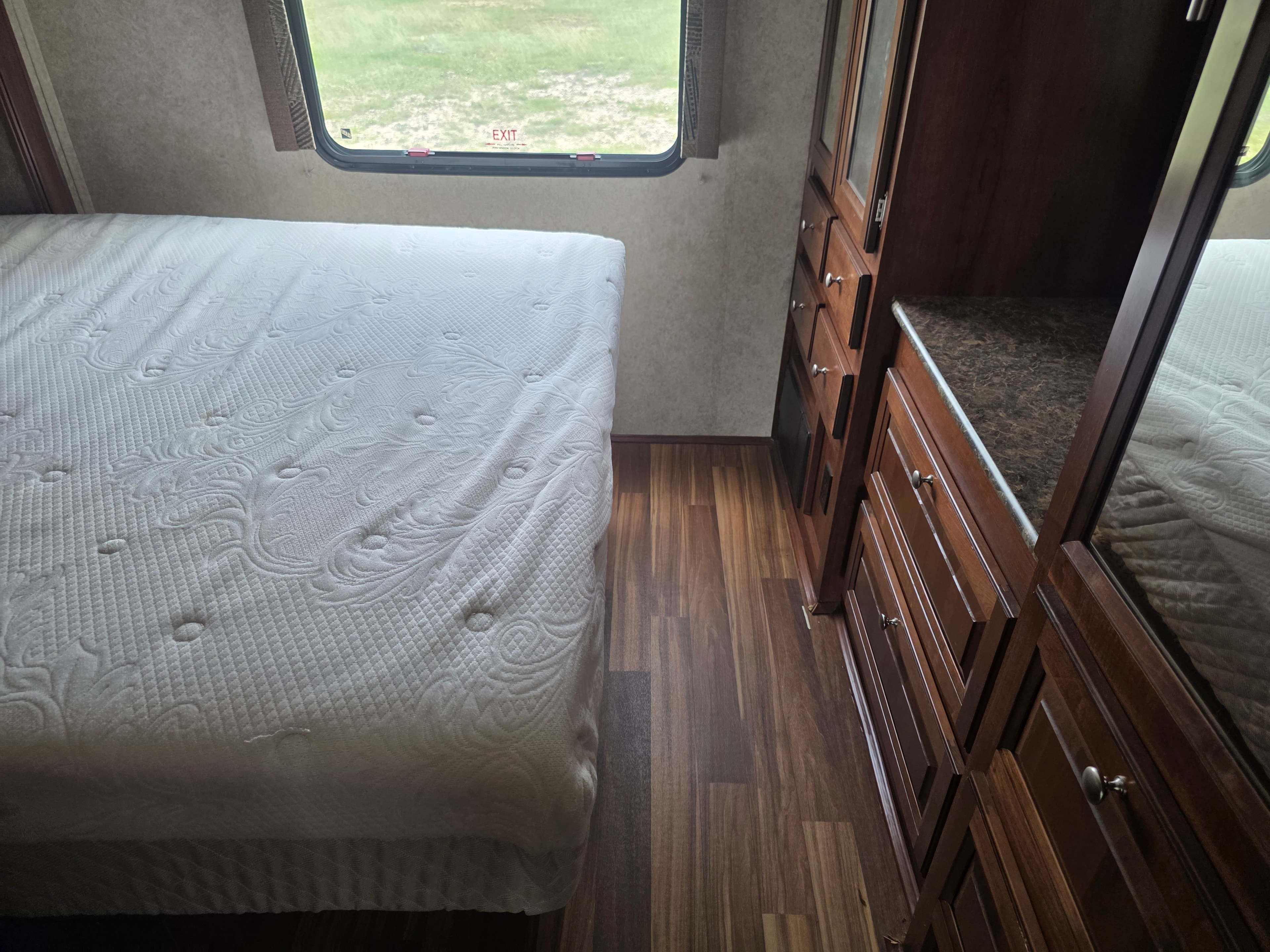 2014 Forest River Georgetown – bedroom with bed slide out, dresser drawers, exit window and scuff-free wood flooring