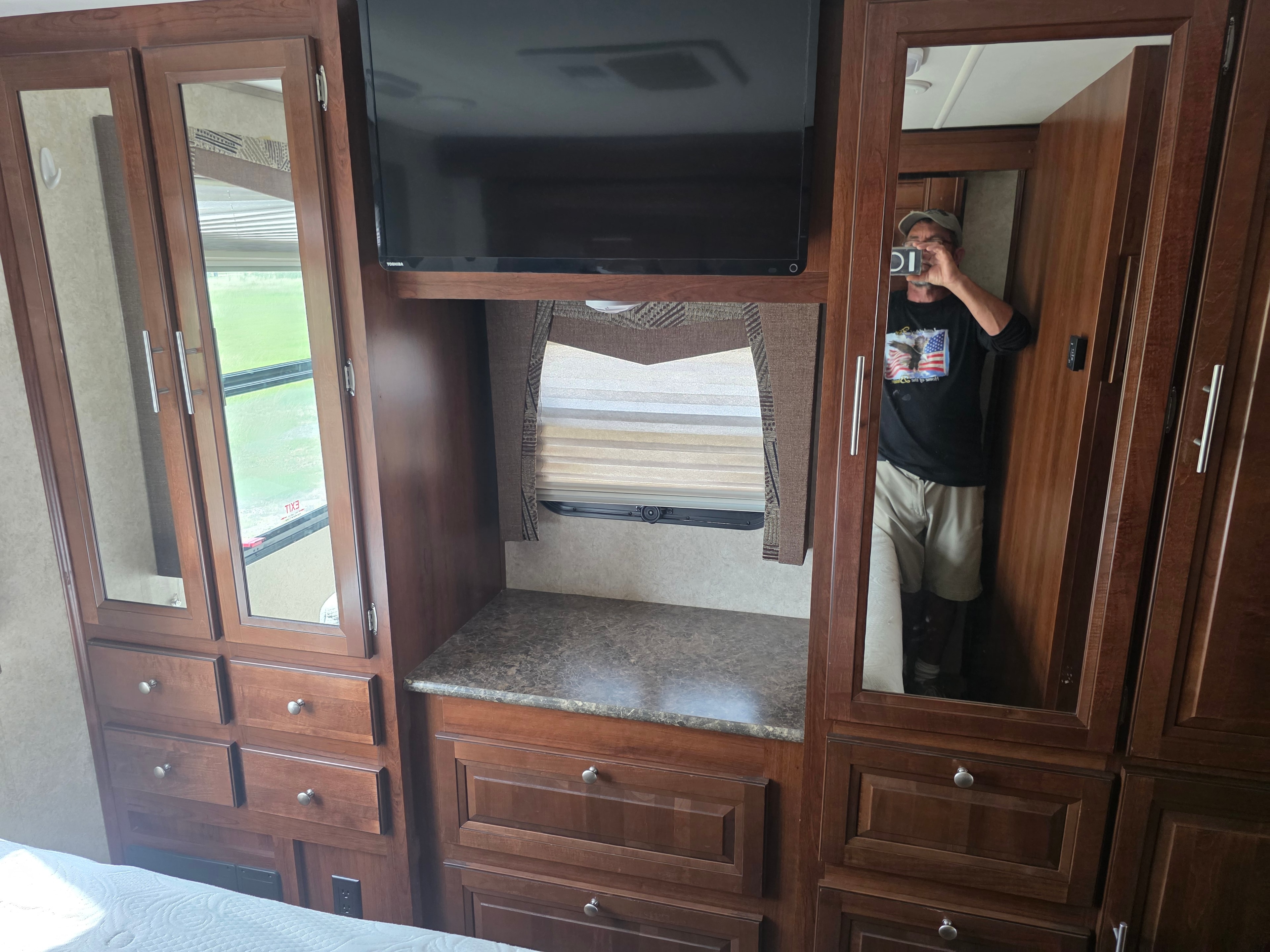 2014 Forest River Georgetown – bedroom entertainment wall with Toshiba TV, mirrored wardrobes, granite countertop and drawers