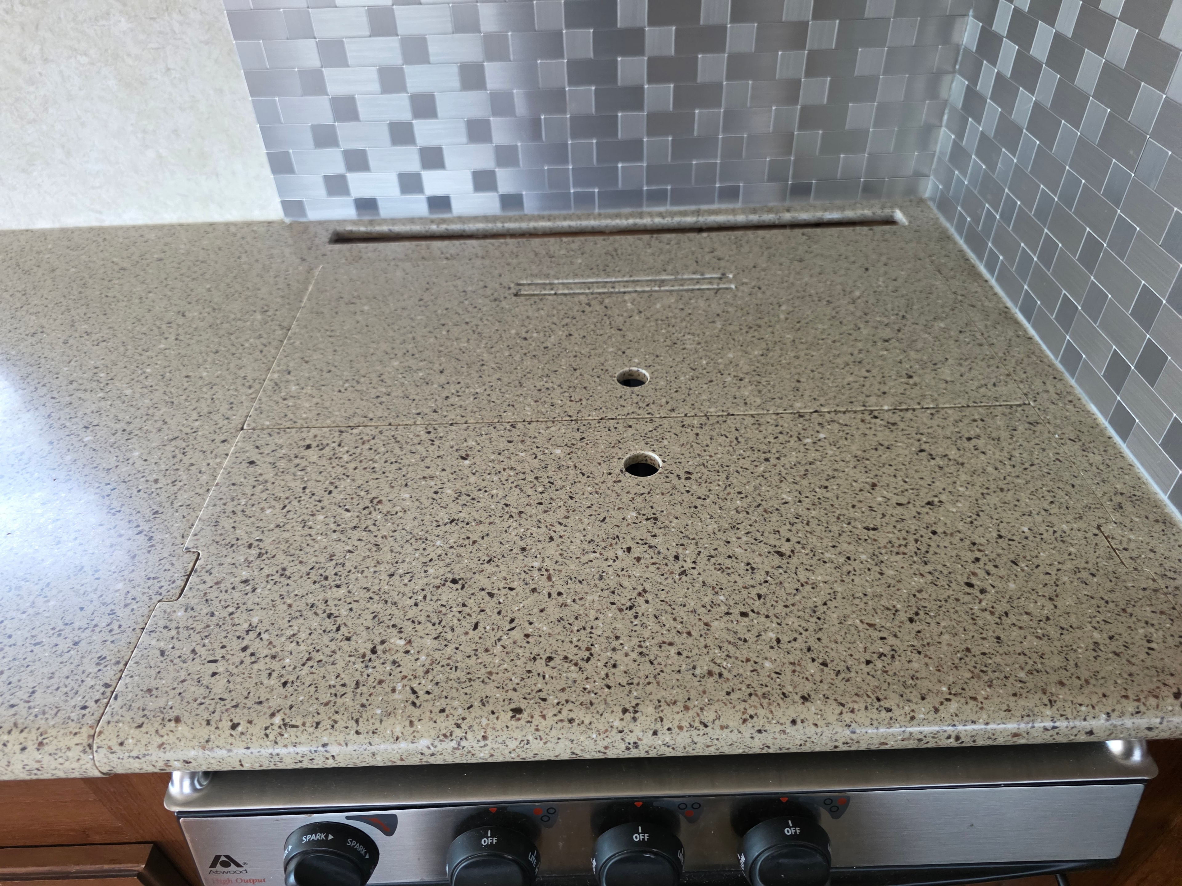 2014 Forest River Georgetown – cooktop with granite cover closed showing clean countertop and tile backsplash