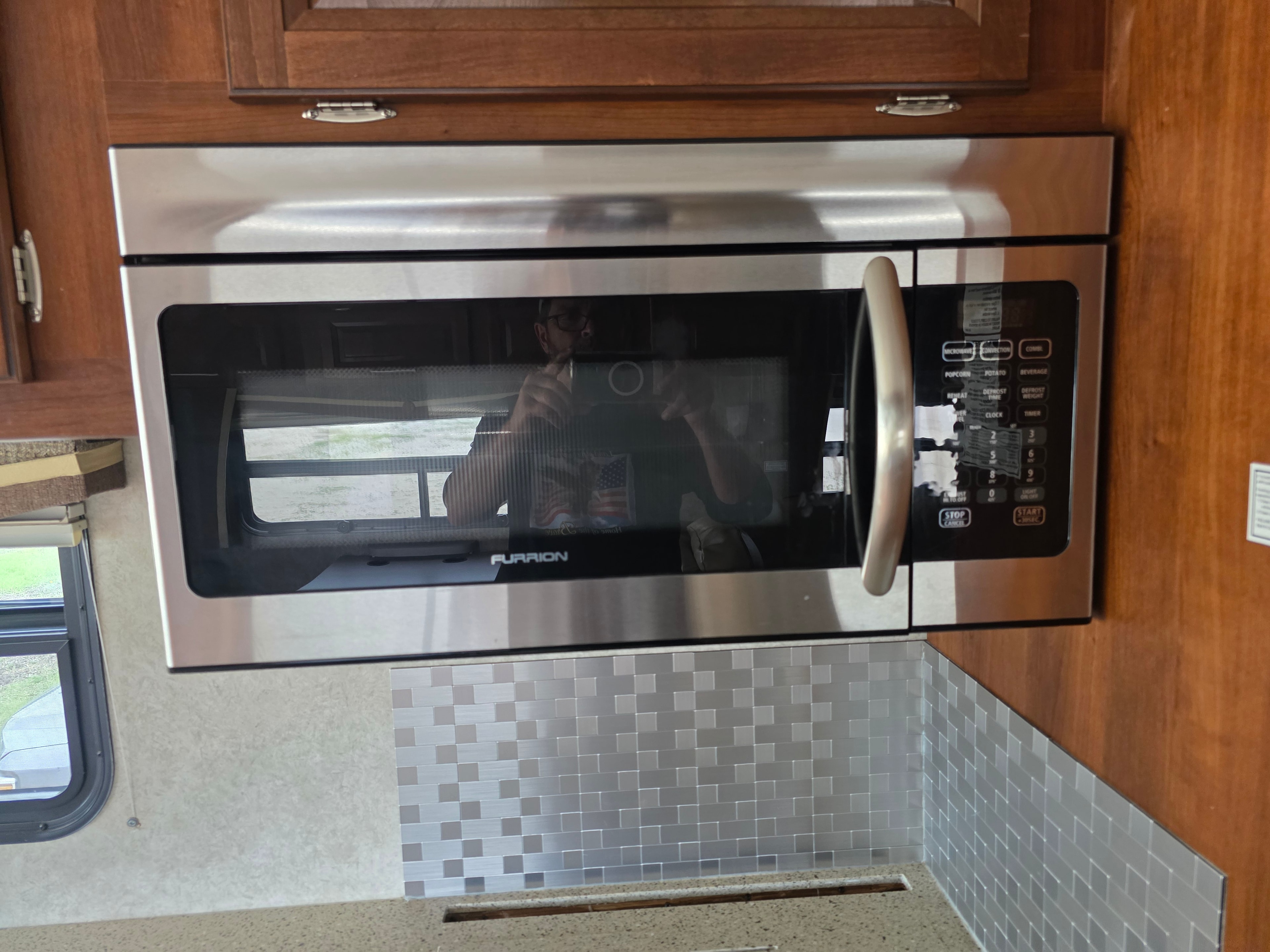 2014 Forest River Georgetown – Furrion stainless convection microwave built into wood cabinetry with tile backsplash