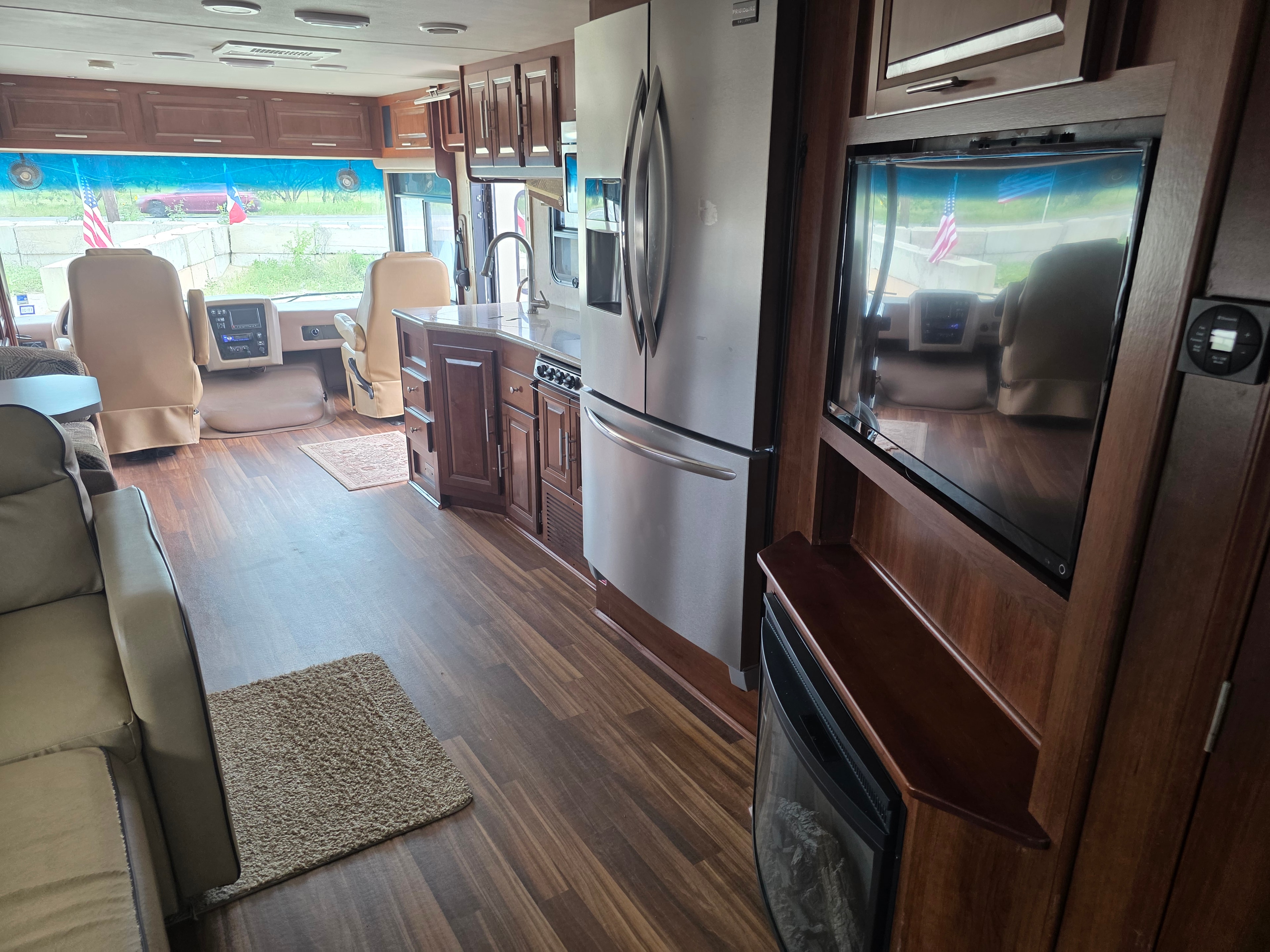 2014 Forest River Georgetown – full interior view from bedroom end showing residential fridge, living area TV, electric fireplace and cockpit