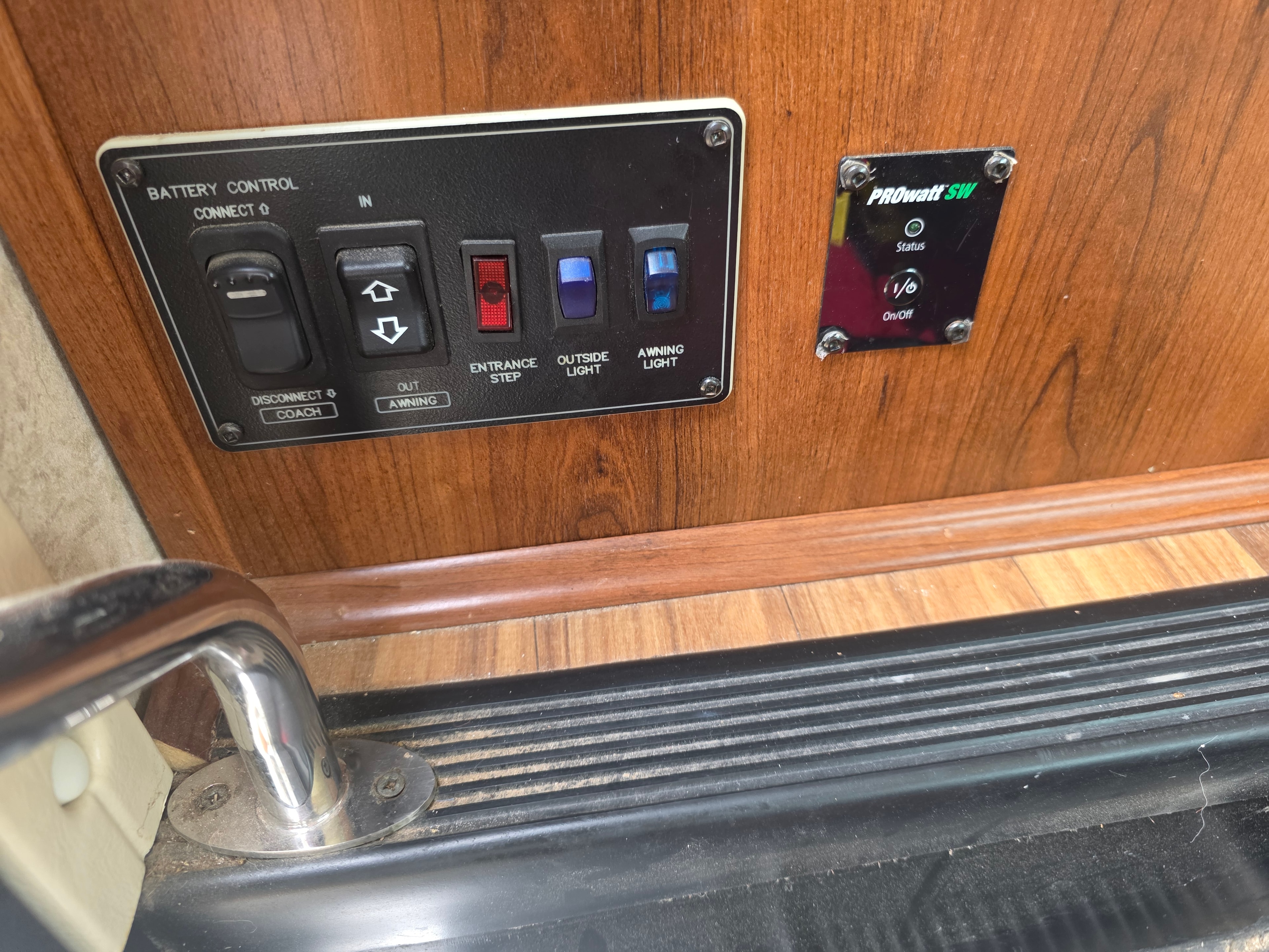 2014 Forest River Georgetown – entry door panel with battery control, awning in/out, entrance step, outside light, awning light switches and PROWatt SW inverter