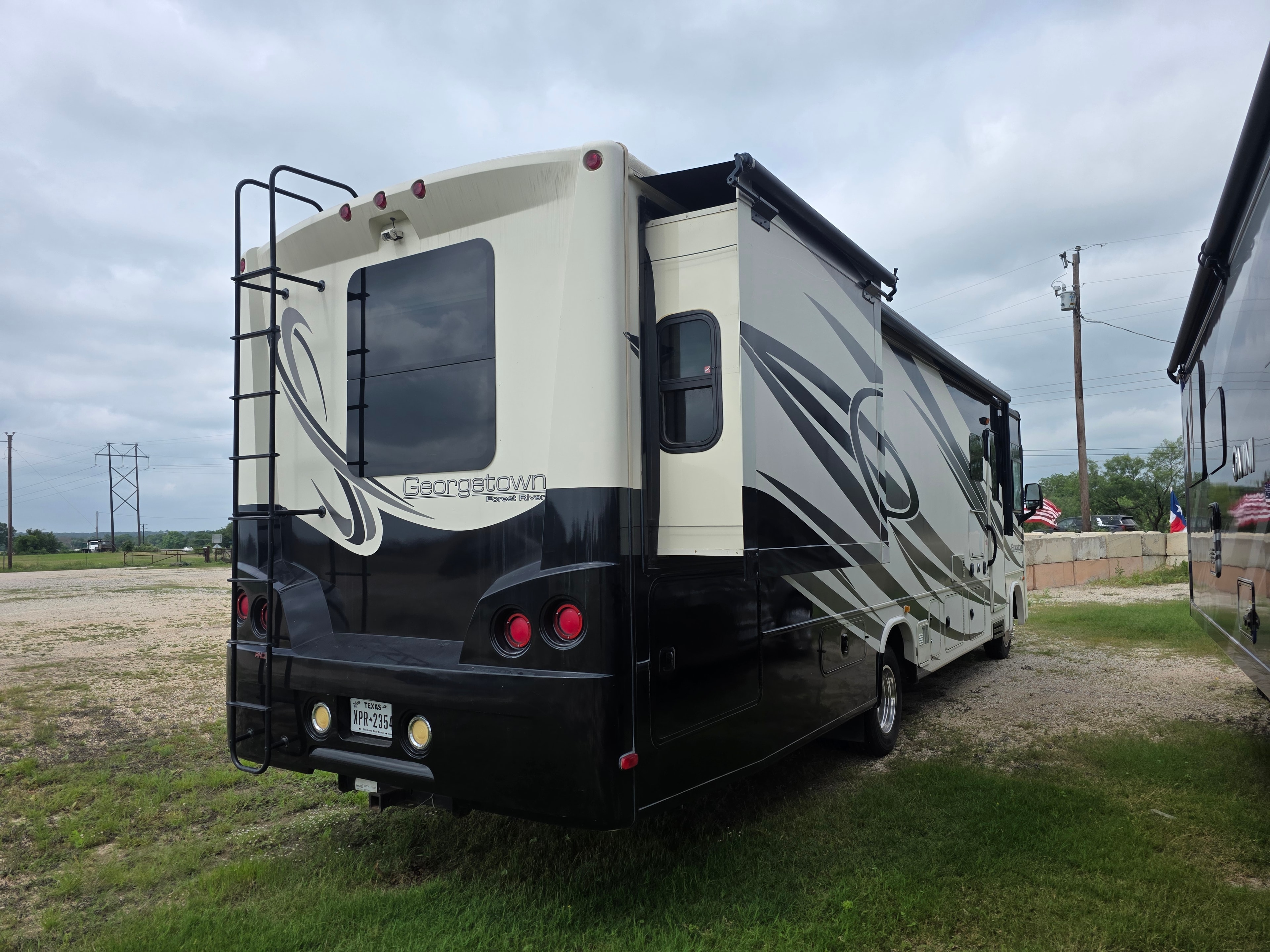 2014 Forest River Georgetown – rear quarter with Georgetown badge, roof ladder and Texas license plate