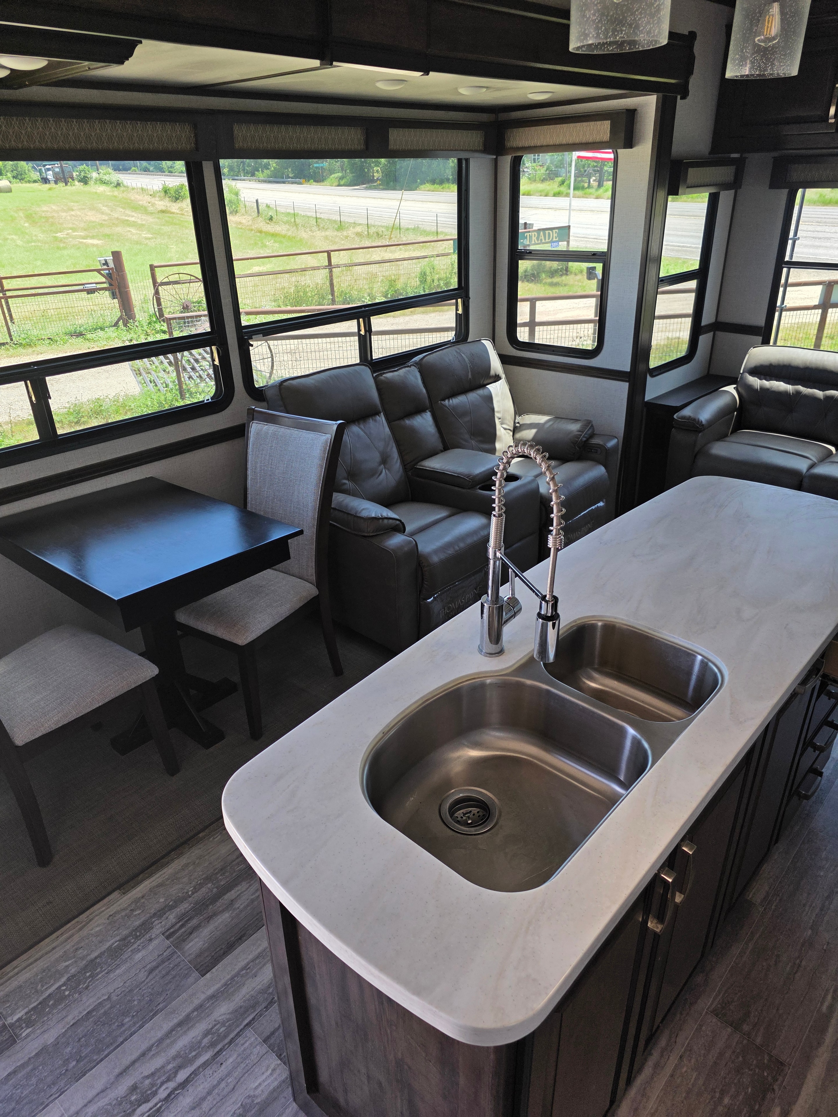 2021 Yukon Dutchmen 320RL – kitchen island sink with living room and panoramic windows