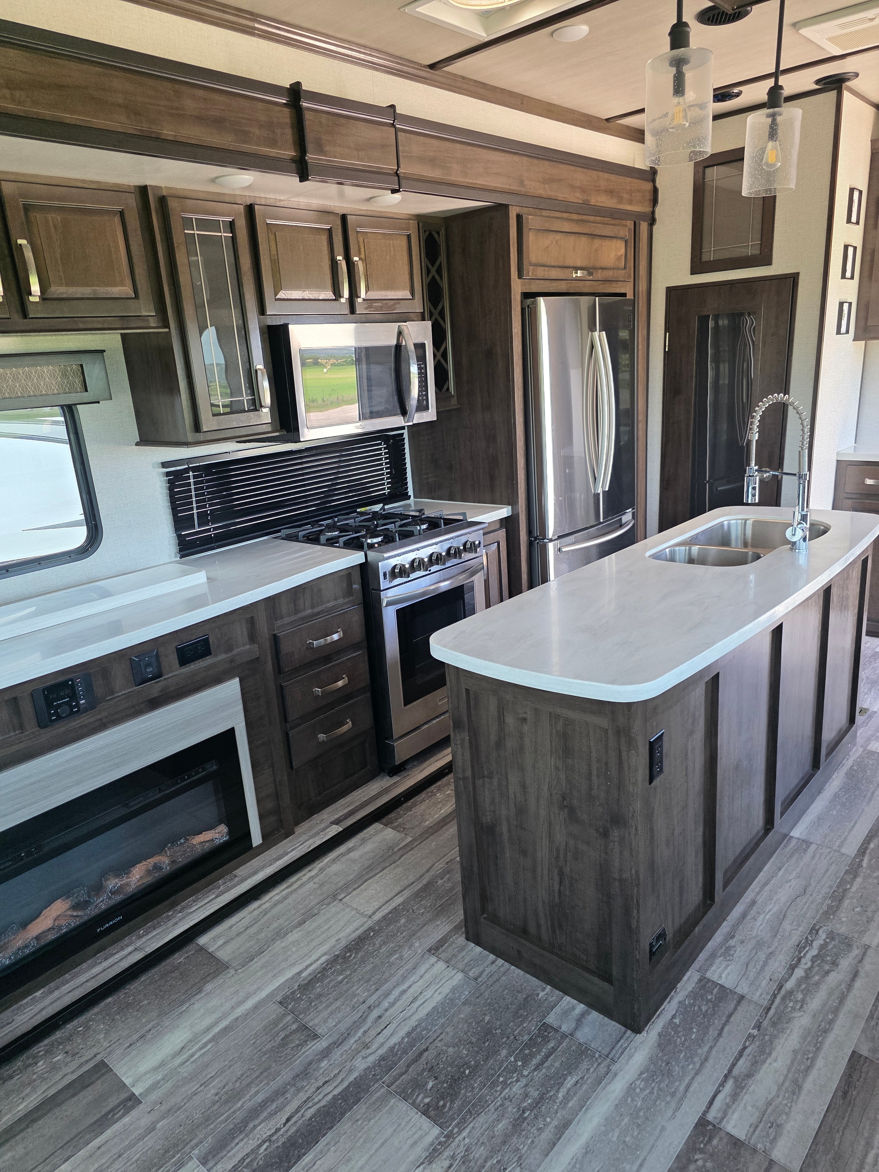 2021 Yukon Dutchmen 320RL – full kitchen with stove, microwave, island and fireplace