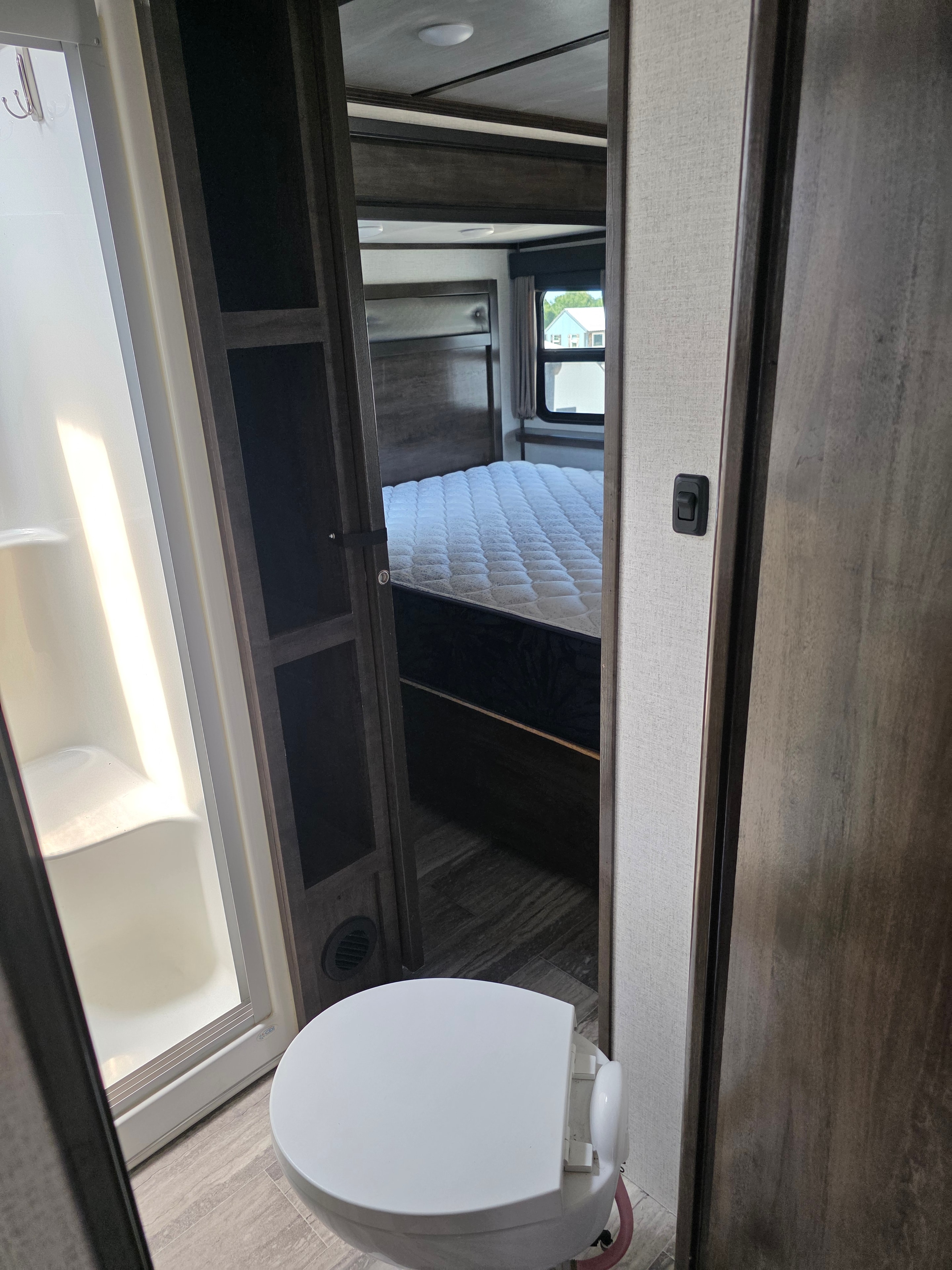 2021 Yukon Dutchmen 320RL – bathroom with toilet and view to master bedroom