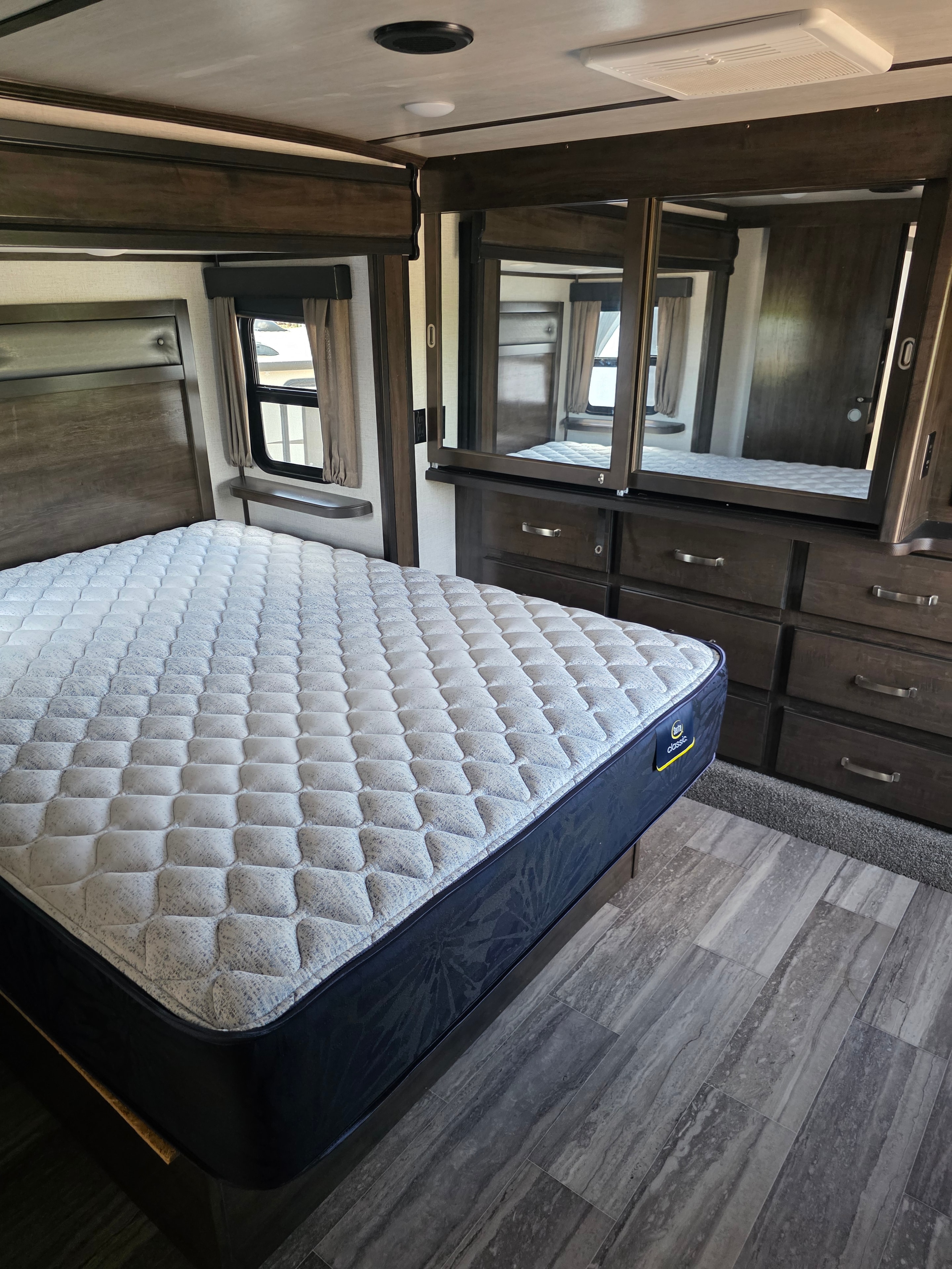 2021 Yukon Dutchmen 320RL – master bedroom with Serta Classic mattress and storage