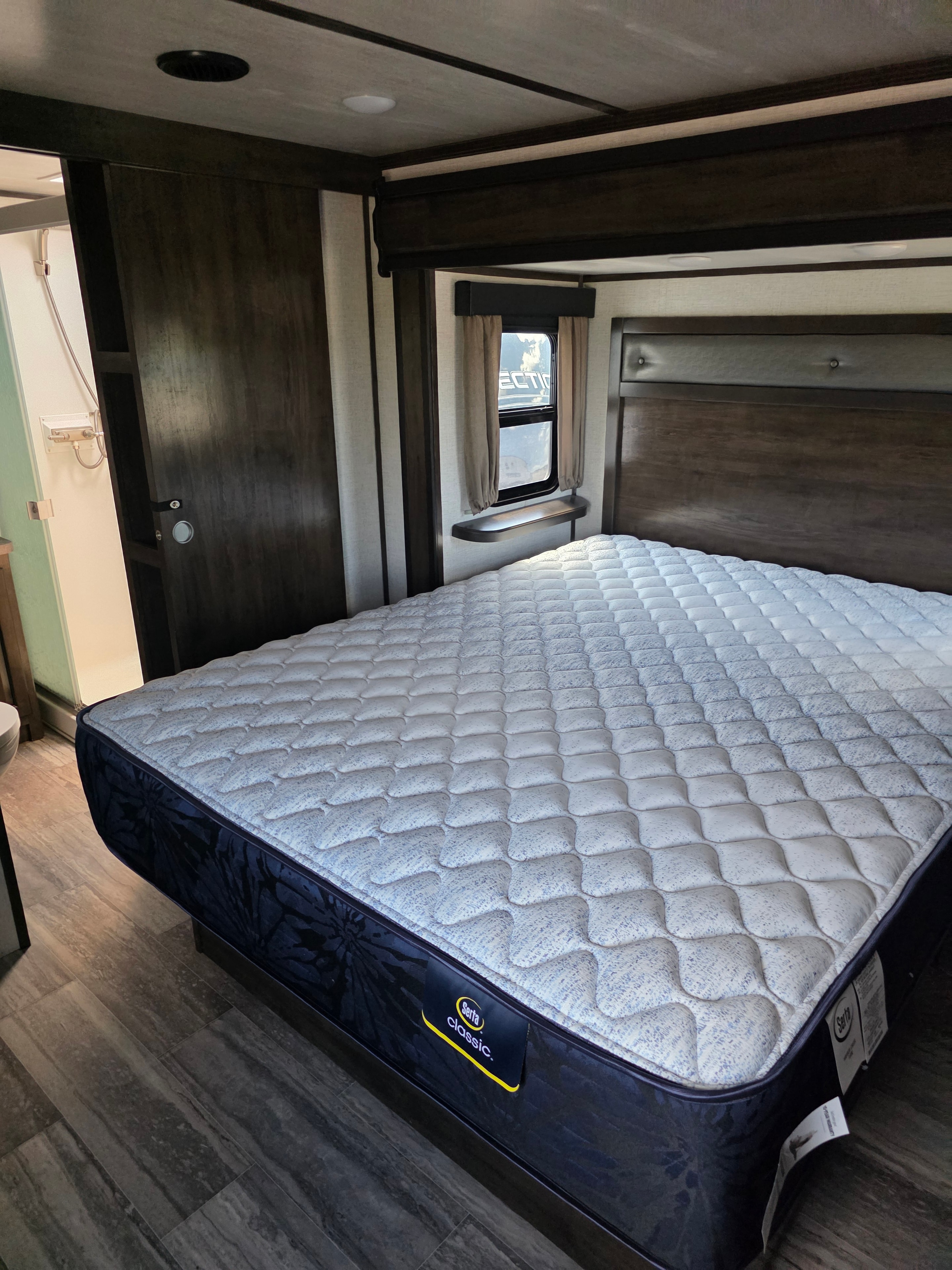 2021 Yukon Dutchmen 320RL – master bedroom with Serta Classic mattress and wardrobe view