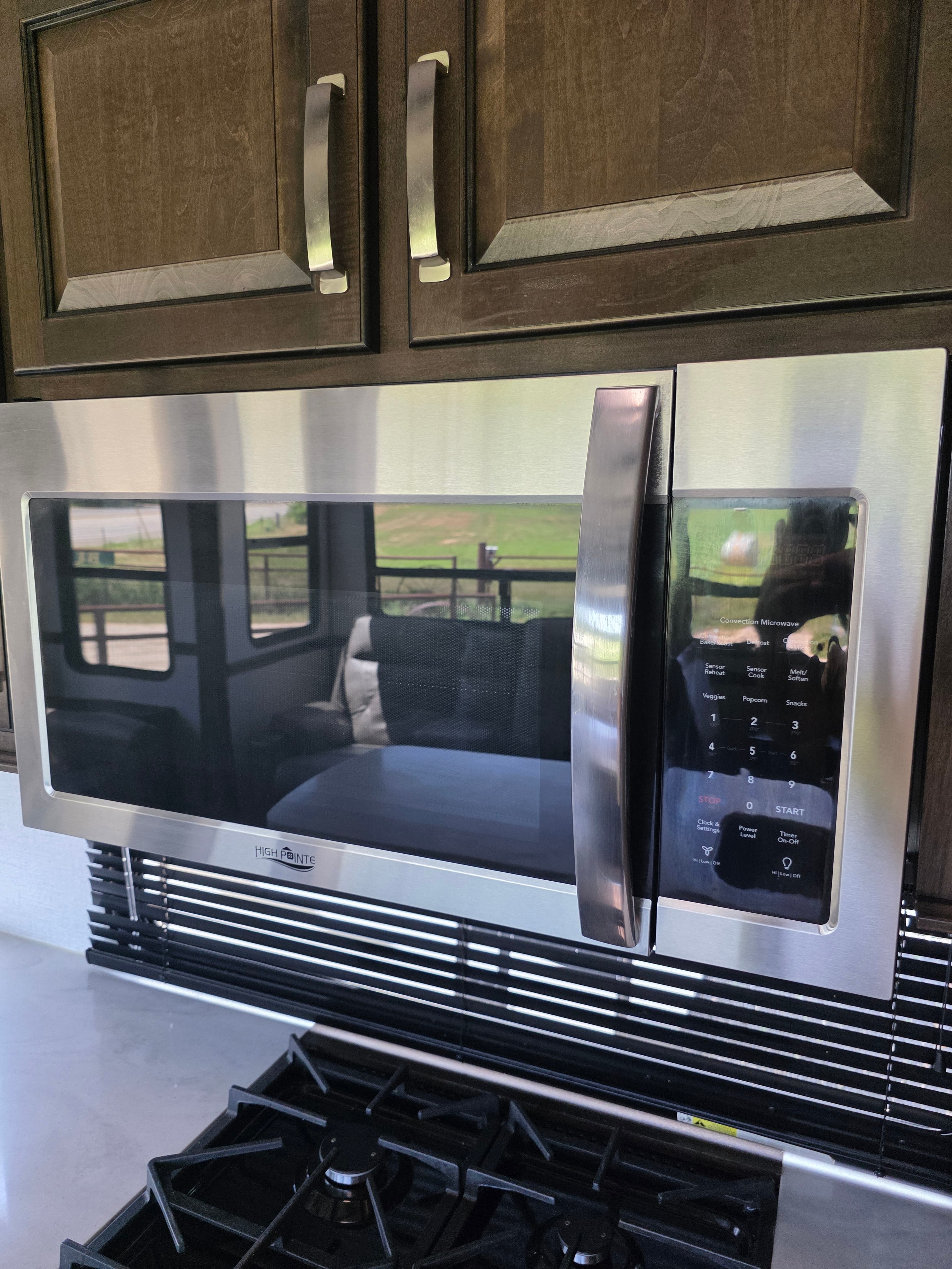 2021 Yukon Dutchmen 320RL – High Pointe convection microwave and gas range close-up