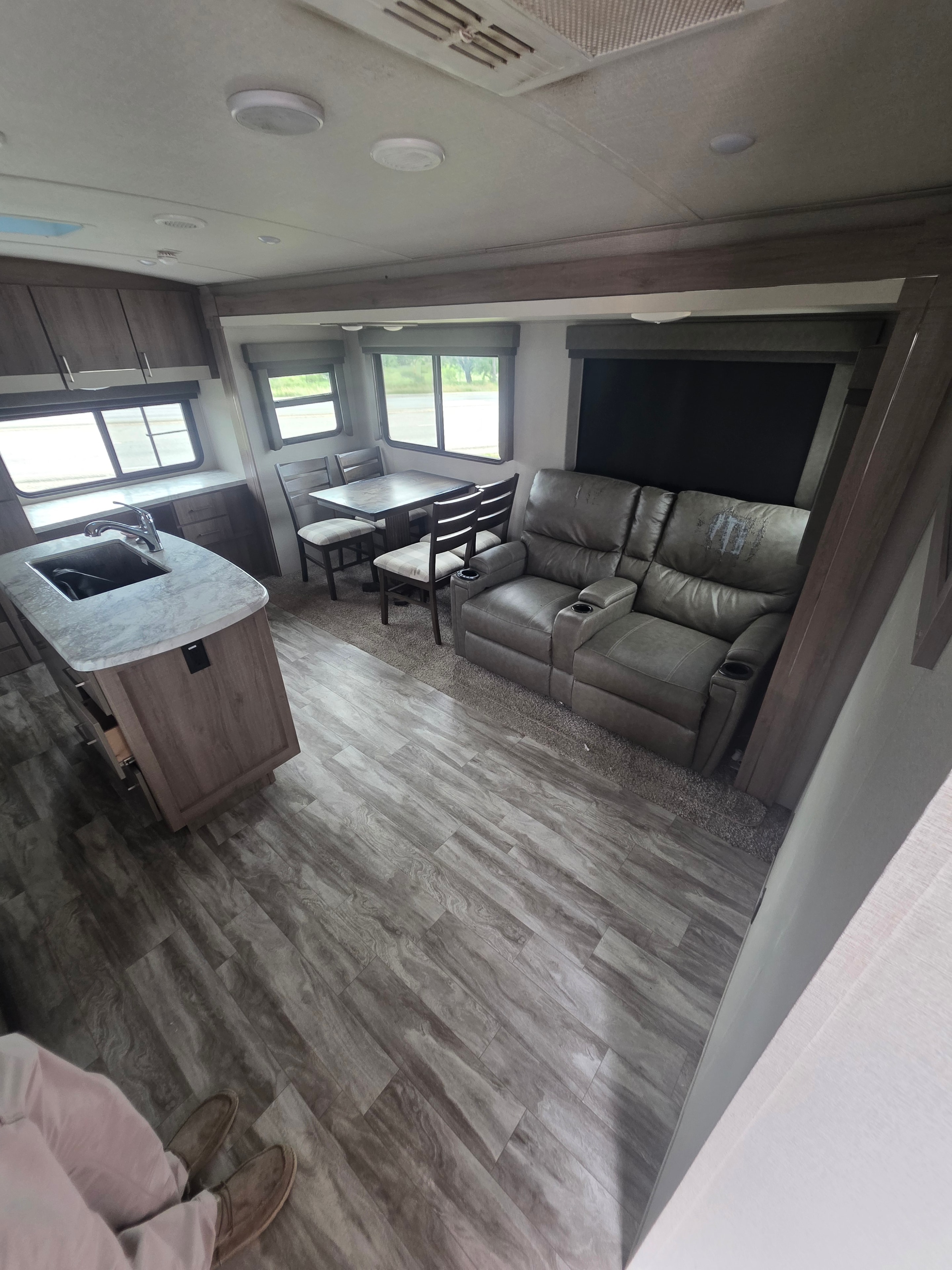 2022 Grand Design Imagine 2670MK – theater seating with gray wood flooring, dining table and chairs