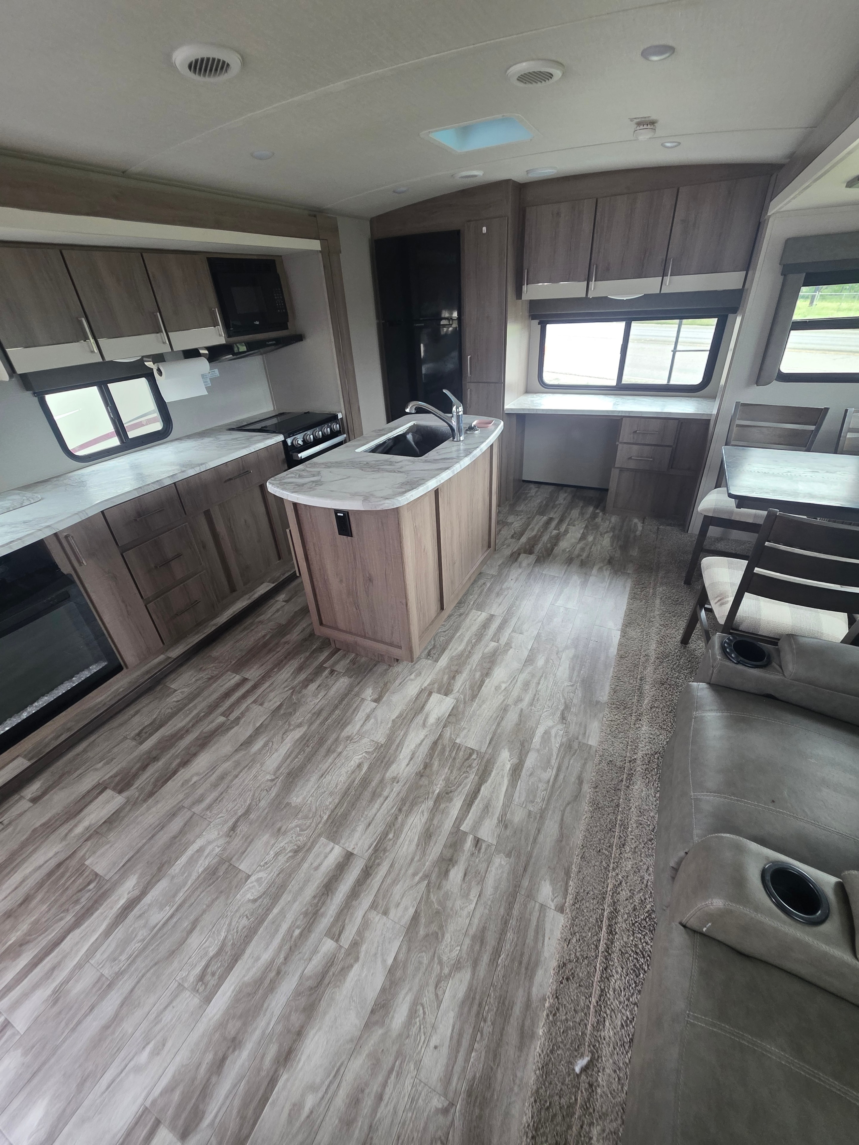 2022 Grand Design Imagine 2670MK – kitchen island with marble countertop, sink, gas range, microwave and living area