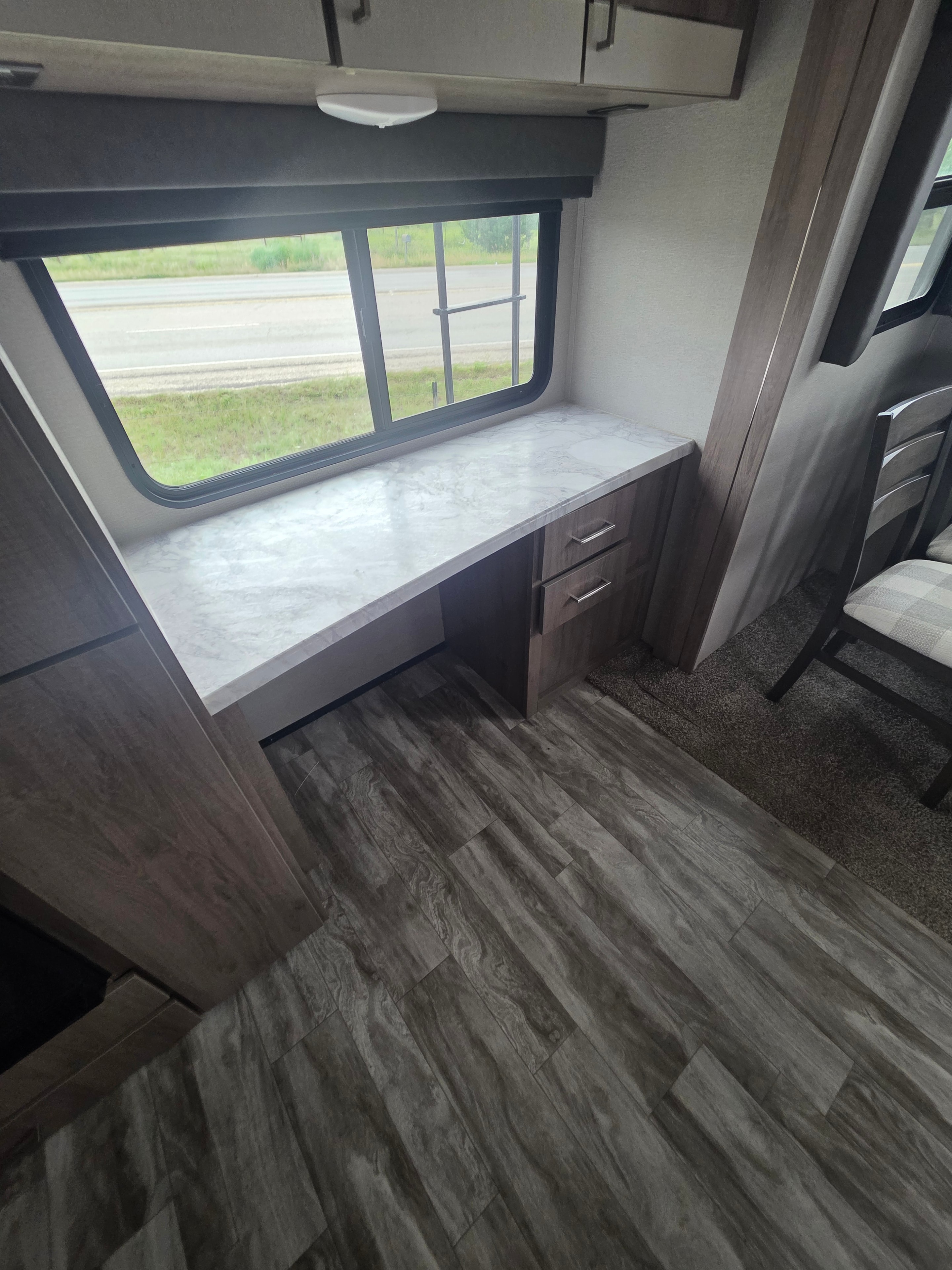 2022 Grand Design Imagine 2670MK – built-in desk with window, overhead cabinets and dining area view