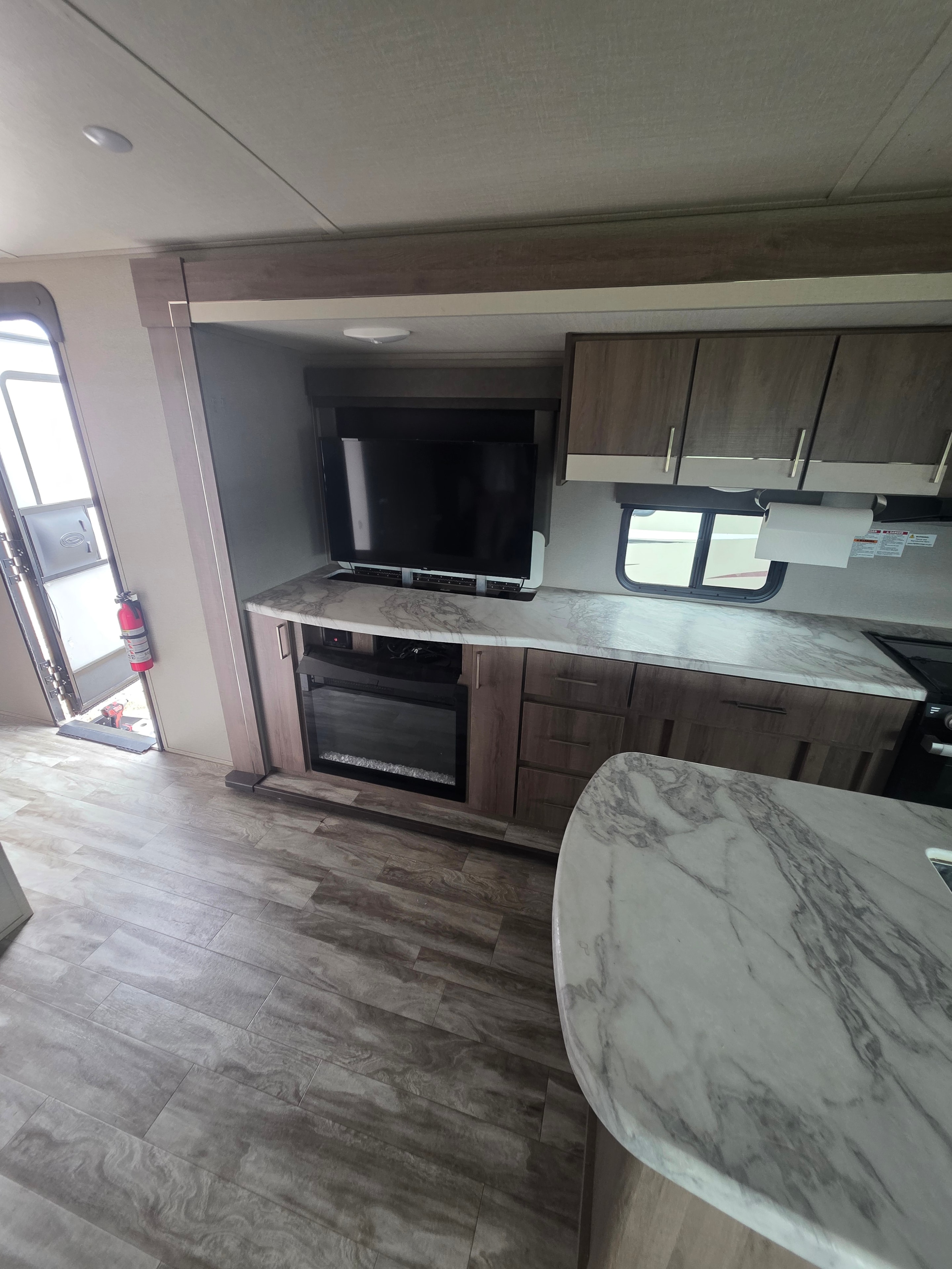 2022 Grand Design Imagine 2670MK – kitchen island with marble countertop, sink, gas range, microwave and dining table