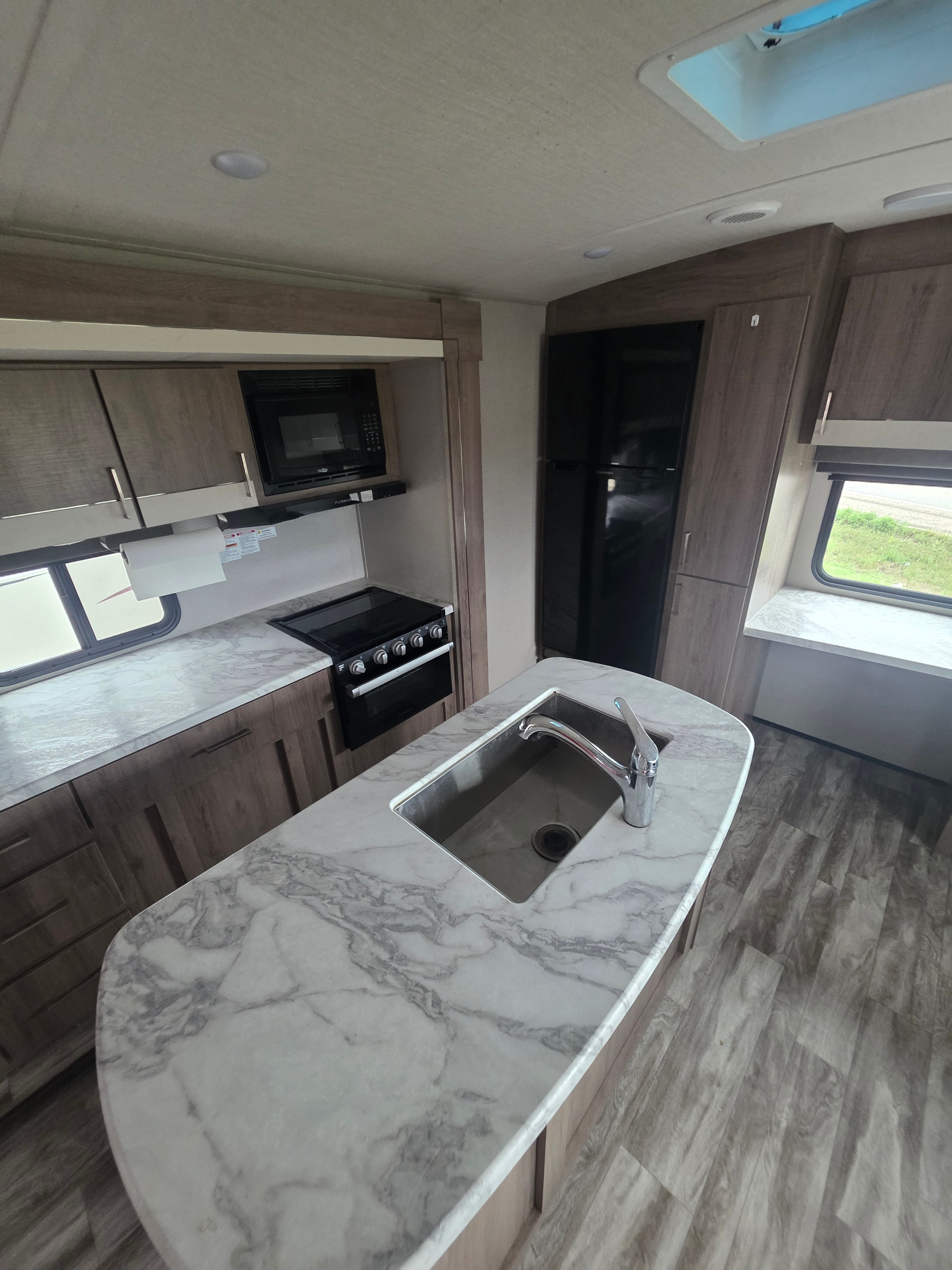 2022 Grand Design Imagine 2670MK – kitchen island close-up with marble countertop, stainless sink and chrome faucet